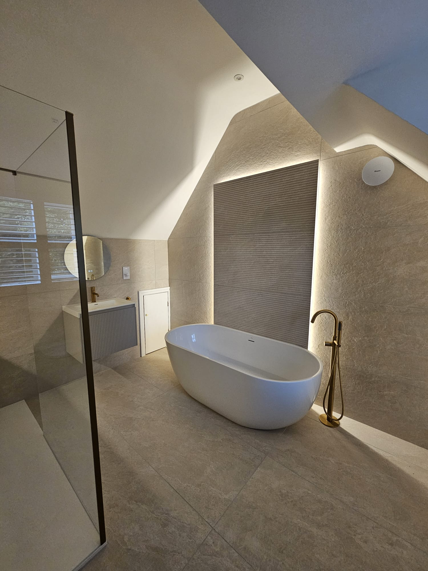 Renofurb bathroom project with a freestanding bath, walk-in shower, stone-effect tiles and brass fittings